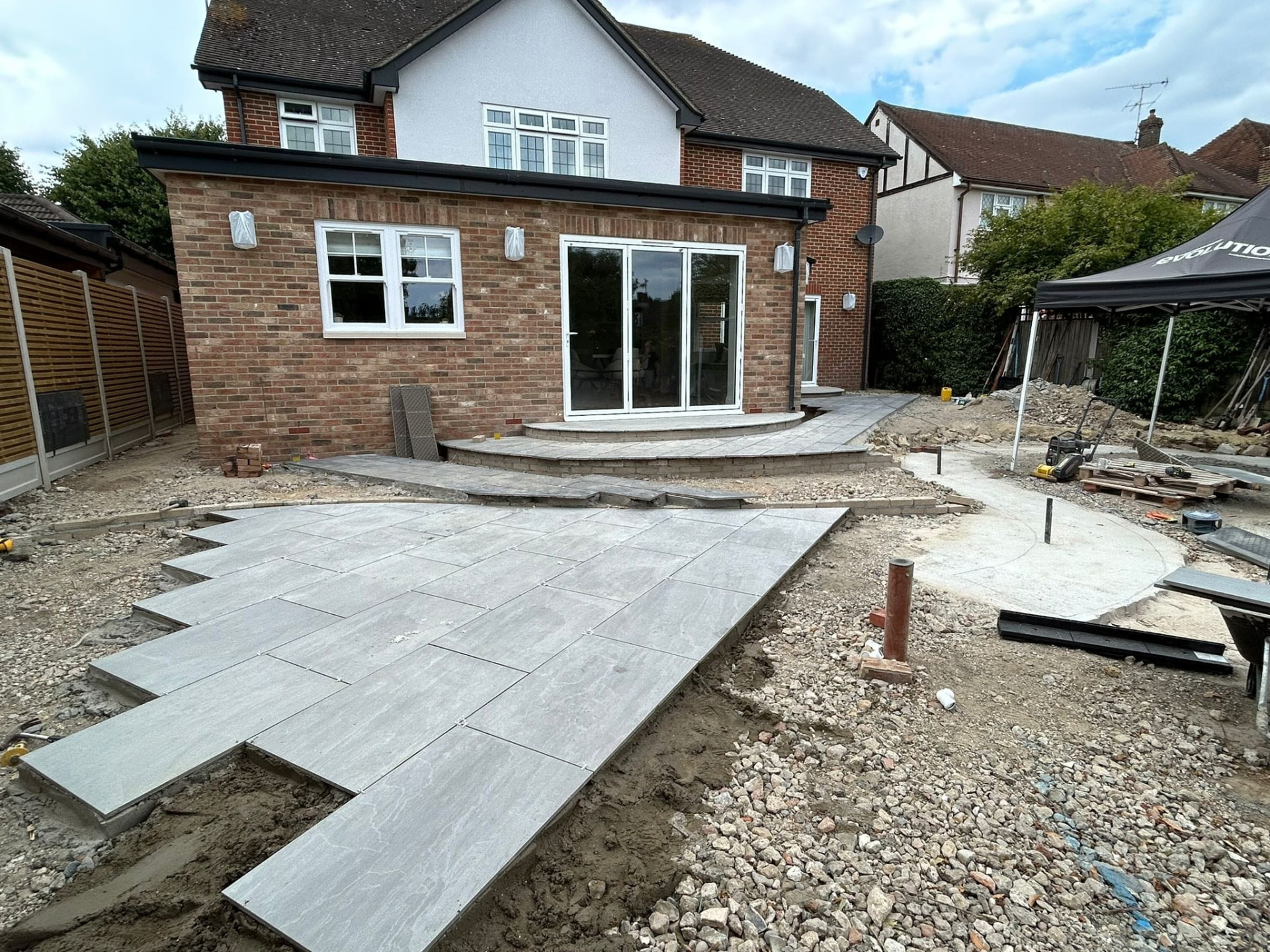 Curved steps and paving under construction in a sloping Essex garden